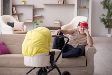 Aged man looking after newborn at home