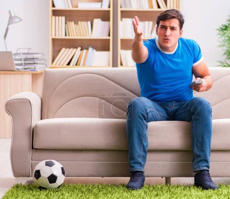 Photo for The man watching football at home sitting in couch - Royalty Free Image