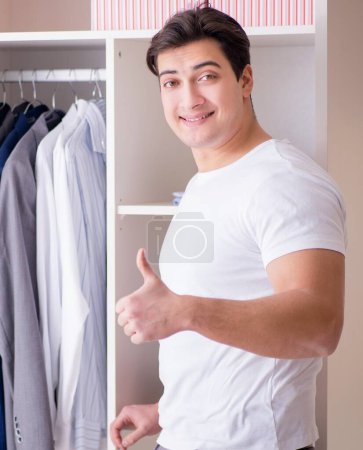 Photo for The young man businessman getting dressed for work - Royalty Free Image