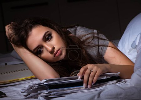 Foto de La mujer de negocios cansada trabajando horas extras en casa por la noche - Imagen libre de derechos