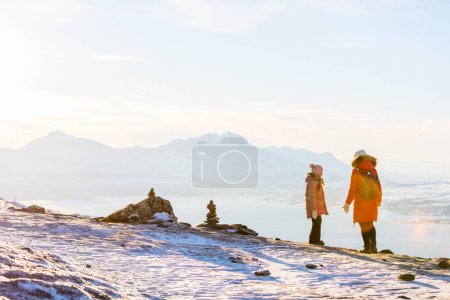 Téléchargez les photos : Belle famille de mère et fille profitant d'une journée d'hiver enneigée en plein air dans le nord de la Norvège - en image libre de droit