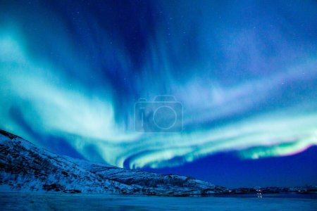 Foto de Increíble actividad de Aurora Boreal sobre la costa en Noruega - Imagen libre de derechos