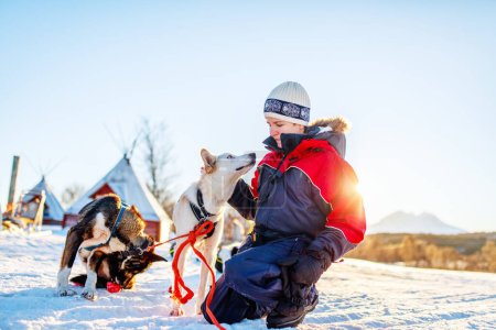 Photo for Teenage boy having a cuddle with husky sled dog in Northern Norway - Royalty Free Image