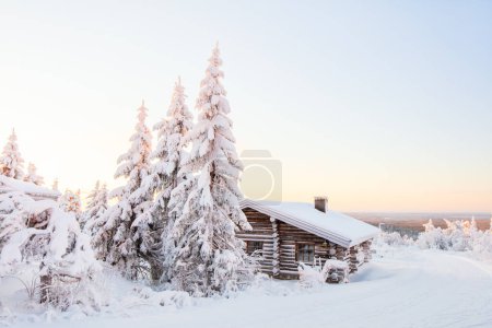 Photo for Beautiful winter landscape with wooden hut and snow covered trees in Lapland Finland - Royalty Free Image