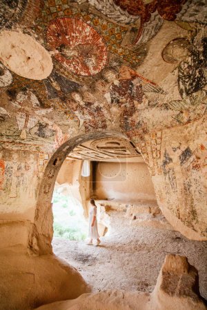 Téléchargez les photos : Young woman touring cave church of Three Crosses in Rose Valley in Cappadocia Turkey dated back to 10th century - en image libre de droit