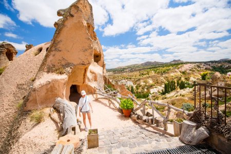 Photo for Young girl exploring valley with rock formations and fairy chimneys near Uchisar castle in Cappadocia Turkey - Royalty Free Image