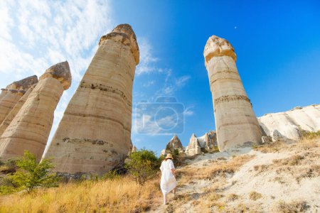 Téléchargez les photos : Young woman walking in Love valley in Cappadocia Turkey among rock formations and fairy chimneys - en image libre de droit