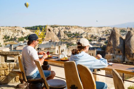 Photo for Family of father and daughter having breakfast outdoors in Cappadocia Turkey - Royalty Free Image