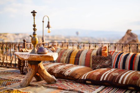 Foto de Detalles interiores decoración primer plano de hermosas almohadas, alfombra, mesa de madera y shisha - Imagen libre de derechos