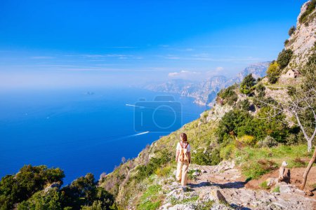 Téléchargez les photos : Jeune femme bénéficiant d'une vue imprenable sur la côte amalfitaine en Italie tout en randonnant sentier pittoresque Sentier des Dieux - en image libre de droit