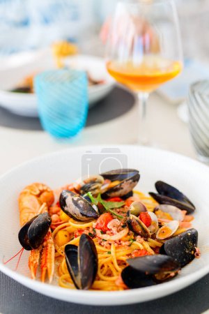 Photo for Delicious seafood spaghetti served with white wine for lunch or dinner in restaurant - Royalty Free Image