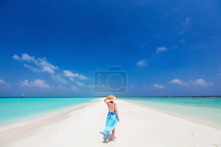 Téléchargez les photos : Jeune femme sur une plage tropicale de sable blanc entourée d'eau de mer turquoise des Maldives - en image libre de droit
