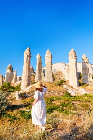 Foto de Young woman walking in Love valley in Cappadocia Turkey among rock formations and fairy chimneys - Imagen libre de derechos