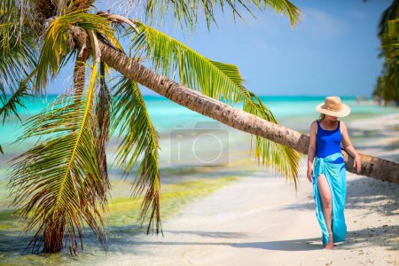 Foto de Mujer joven en la playa tropical de arena blanca rodeada de aguas turquesas del océano de Maldivas - Imagen libre de derechos