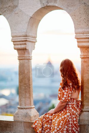 Photo for Back view of caucasian woman enjoying morning view over Parliament in Budapest from Fisherman Bastion - Royalty Free Image