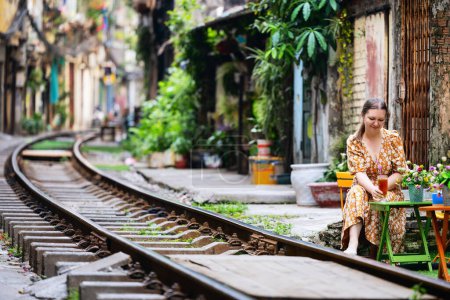 Photo for Beautiful woman at cafe near railway tracks in Hanoi Vietnam - Royalty Free Image