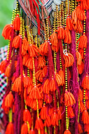 Téléchargez les photos : Gros plan sur le foulard traditionnel des minorités ethniques dao vietnamiennes décoré de pièces d'argent et de glands - en image libre de droit