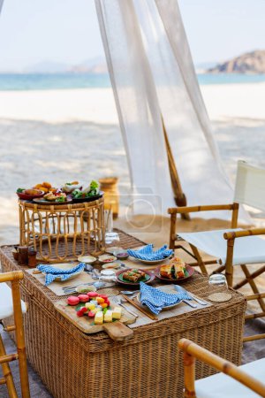 Photo for Luxury picnic on beautiful white sand beach at sunset - Royalty Free Image