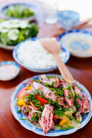 Téléchargez les photos : Délicieux calamars aux légumes servis avec du riz blanc pour le déjeuner au restaurant - en image libre de droit