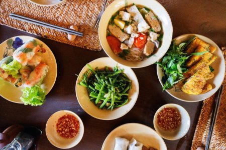 Photo for Top view of spring rolls,  fish noodle soup and vietnamese pancakes dishes - Royalty Free Image