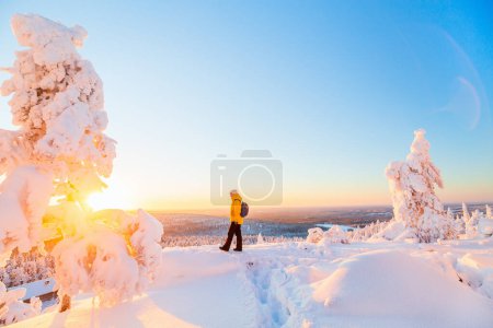 Foto de Mujer joven disfrutando de impresionantes vistas sobre el bosque de invierno con árboles cubiertos de nieve en Laponia Finlandia - Imagen libre de derechos