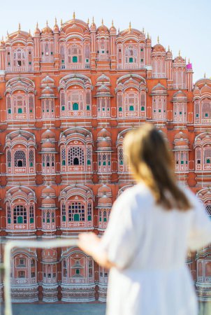 Photo for Back view of beautiful woman enjoying view of Hawa mahal in Jaipur India. Selective focus on the building. - Royalty Free Image