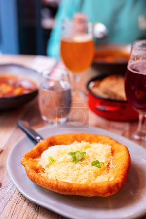 Photo for Hungarian traditional food langos. Flatbread with sour cream and cheese. - Royalty Free Image