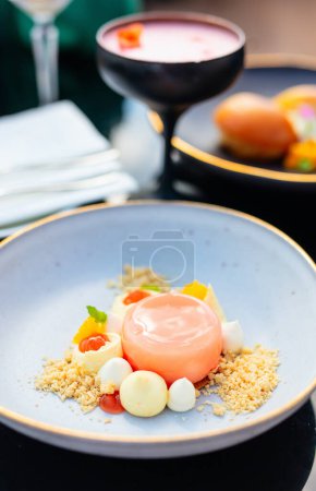 Photo for Close up of delicious dessert and cocktail served on black tableware at fancy bar or restaurant - Royalty Free Image