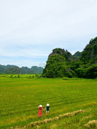 Photo for Beautiful couple enjoys travel through Southeast Asia contemplating the views of countryside and rice fields in Ninh Binh Vietnam - Royalty Free Image