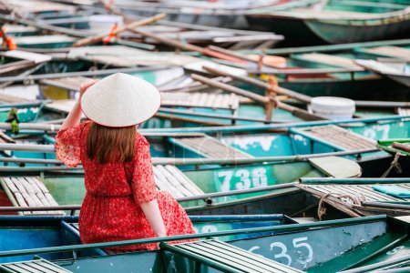 Photo for Back view of caucasian woman enjoying view of hundreds of boats parked at Tam Coc pier in Vietnam - Royalty Free Image