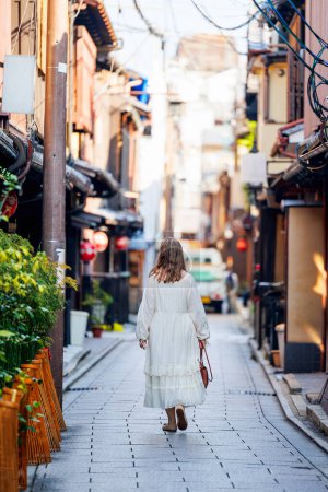 Téléchargez les photos : Vue arrière de la belle femme marchant à Gion Kyoto tôt le matin - en image libre de droit