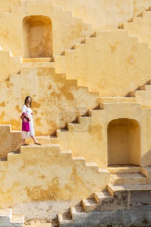 Femme marchant dans les escaliers de l'ancien stepwell à Jaipur en Inde