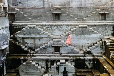 Photo for Woman walking down stairs at ancient stepwell in Jaipur India - Royalty Free Image