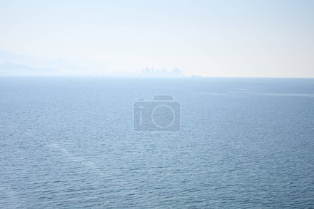 Téléchargez les photos : Panoranic view of sea with city on horizin in the haze. - en image libre de droit