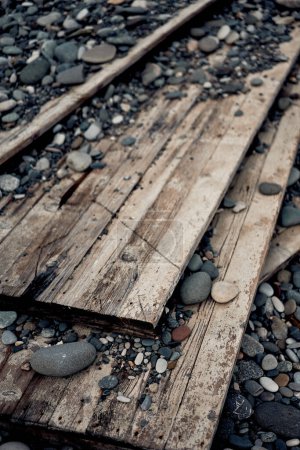 Téléchargez les photos : Old rusty wooden wall lying down on beach. - en image libre de droit