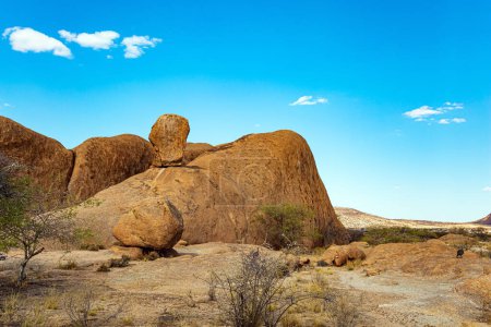 Téléchargez les photos : Magnifiques restes de pierre rouge-orange de Spitzkoppe de granit grossier. D'énormes rochers arrondis au milieu du désert namibien sans fin. L'Afrique. Namibie. - en image libre de droit