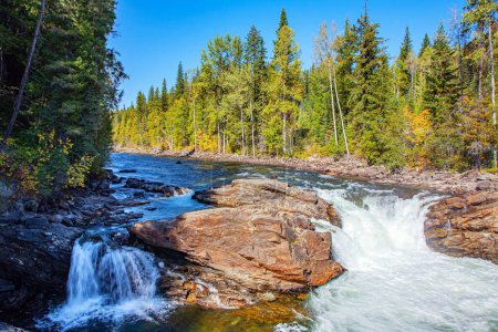 Photo for Stormy mountain river foams on the riffles. The Canadian province of British Columbia. The Caribou Mountains.  Wells Gray is a park in the Rocky Mountains of Canada. - Royalty Free Image