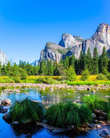 Foto de Pintorescos picos de montaña se reflejan en el agua suave del lago. Hermoso día en el valle del parque. Parque Yosemite se encuentra en las laderas de la Sierra Nevada - Imagen libre de derechos