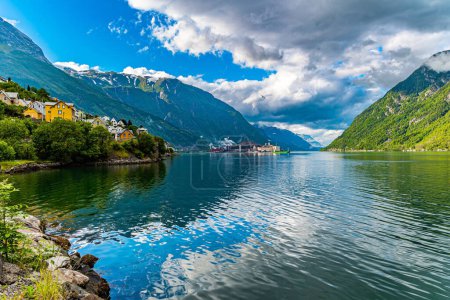 Photo for Magical late summer sunset. Mountains and forests are reflected in the water. Magnificent Hardanger fjord between mountains. Small town of Odda. Travel to Norway in summer. - Royalty Free Image