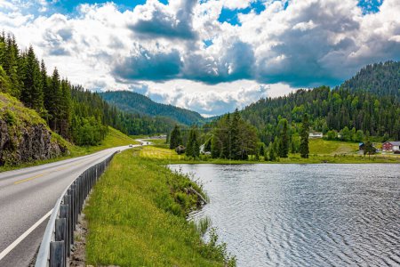 Foto de Camino escénico a Roldal. Hermoso lago entre las verdes colinas florecientes. Cálido día nublado de julio. Viaje al oeste de Noruega. - Imagen libre de derechos