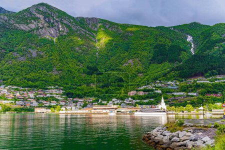 Photo for Magnificent Hardanger fjord between forested mountains. Small town of Odda. Travel to Norway in summer. Magical late summer sunset. Mountains and forests are reflected in the water - Royalty Free Image