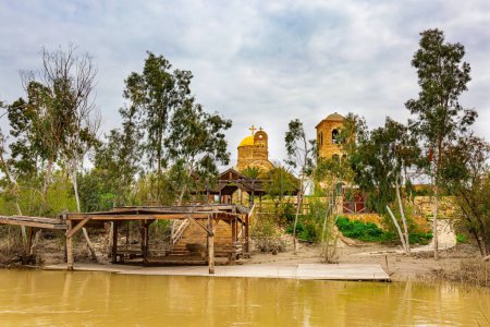 Photo for Smooth yellow water of the Jordan River. Greek Orthodox Church of John the Baptist. Place of the Baptism of Jesus Christ on of the Jordan River in Israel - Qasr el Yahud. - Royalty Free Image