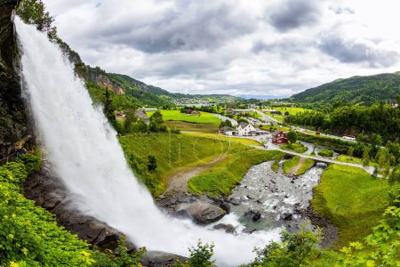 Téléchargez les photos : Énorme cascade bouillonnante Steinsdalsfossen. Journée d'été dans les montagnes de Norvège. Aventure passionnante dans le nord. campagne verte pittoresque - en image libre de droit