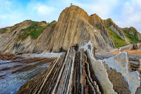 Foto de La playa más inusual del País Vasco - Itsurun. Flysch - paisaje único de rocas submarinas expuestas a la marea baja. Paisaje mágico único. - Imagen libre de derechos