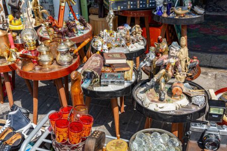 Photo for The bright spring sun illuminates the treasures on the bazaar stalls. Finjans and cezves for coffee, souvenir dolls and figurines. The flea market in Jaffa. Tel Aviv, Israel. - Royalty Free Image