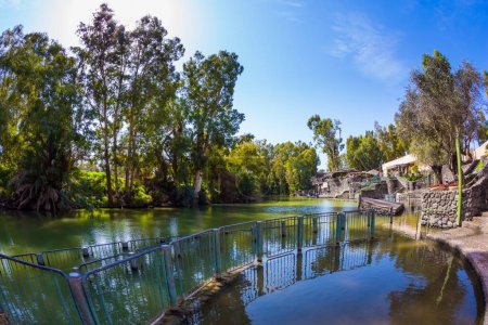 Photo for Religious, ethnographic and photo tourism concept. The place of symbolic baptism is equipped with walkways and partitions. The exit of the Jordan River from Lake Galilee. Yardenit, Israel - Royalty Free Image