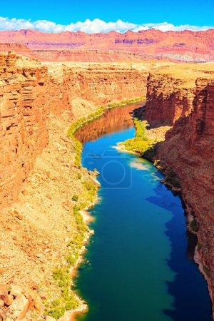 Photo for Deep and narrow canyon of the Colorado River. The multicolored canyon of red Navajo sandstones. The water of the Colorado River reflects the surrounding rocks. United States of America. - Royalty Free Image