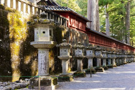 Foto de Paredes de piedra cubiertas de musgo, e incluso filas de faroles de piedra. Nikko Tosho-gu es un santuario sintoísta en Nikko, Japón. Construido en 1617. Tesoro Nacional de Japón. - Imagen libre de derechos