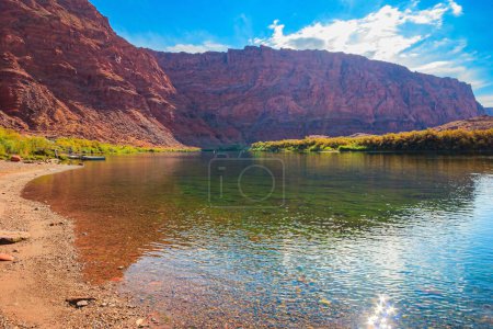 Photo for The multicolored canyon of red Navajo sandstones. The water of the Colorado River reflects the steep rocks. The historic Lees Ferry on the Colorado River. - Royalty Free Image