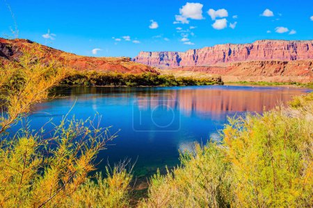 L'eau du Colorado reflète les rochers escarpés. Le canyon multicolore de grès Navajo orange et rouge. Le ferry historique de Lees sur le fleuve Colorado.
